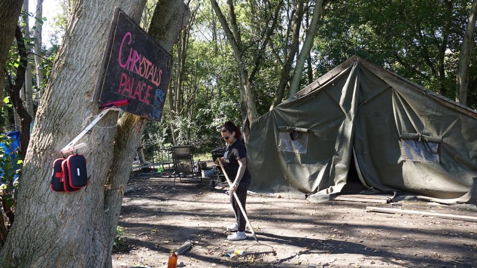 Chrystal Garrity cleans up outside her tent in Belle Park on Sept. 27, 2024.