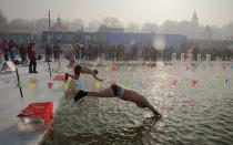 <p>Swimmers dive into a pool cut from the frozen riverbank as part of a winter swimming competition during theHarbin Ice and Snow festival.</p>