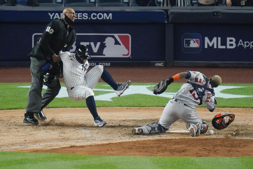 New York Yankees' Rougned Odor falls into the home plate umpire after running past Houston Astros catcher Martin Maldonado, right, to score during the sixth inning of a baseball game Tuesday, May 4, 2021, in New York. (AP Photo/Frank Franklin II)