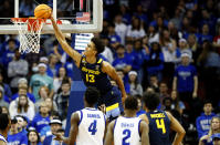 Marquette forward Oso Ighodaro (13) goes to the basket against Seton Hall forward Tyrese Samuel, bottom left, and guard Al-Amir Dawes (2) during the second half of an NCAA college basketball game in Newark, N.J., Saturday, Jan. 21, 2023. (AP Photo/Noah K. Murray)