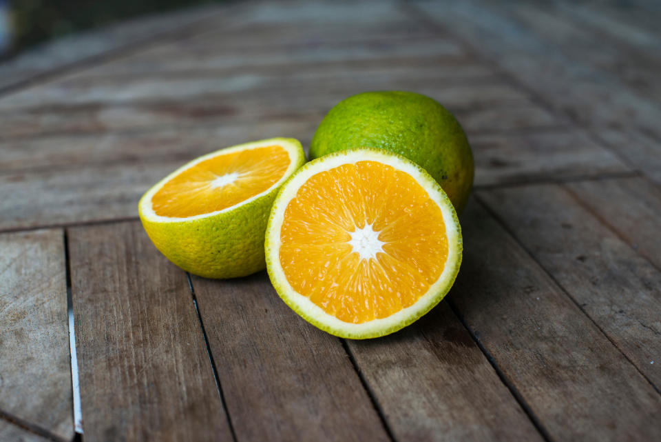 Close-Up Of Oranges On Wooden Table