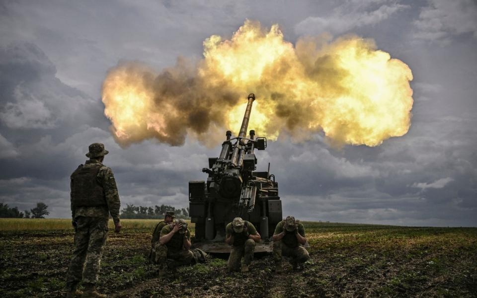 Ukrainian servicemen fire with a French self-propelled 155 mm/52-calibre gun Caesar towards Russian positions at a front line in the eastern Ukrainian region of Donbas  - ARIS MESSINIS/AFP