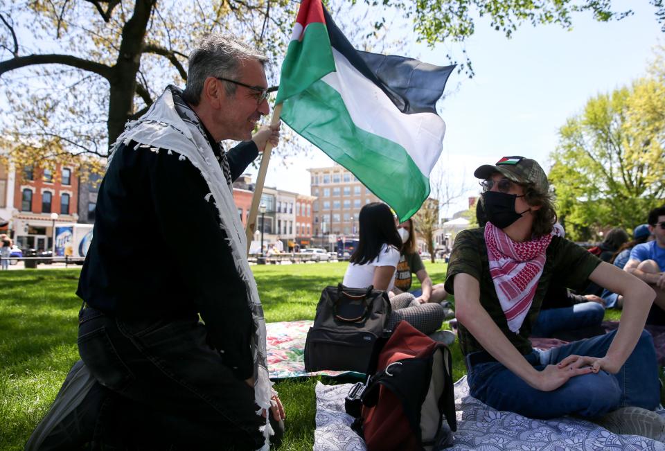 Newman Abuissa, left, speaks with another participant of a demonstration and educational event concerning the Israel-Hamas war Friday, May 3, 2024 on the Pentacrest in Iowa City, Iowa.