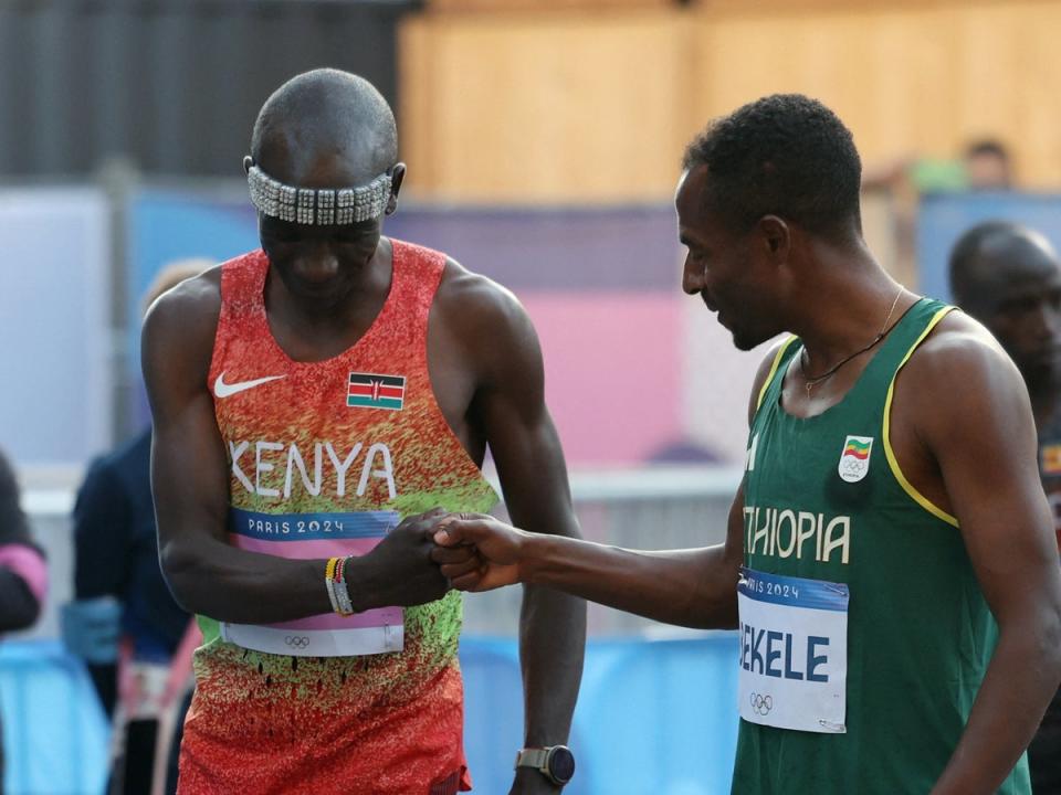 Eliud Kipchoge of Kenya bumps fists with Kenenisa Bekele of Ethiopia before the race (REUTERS)