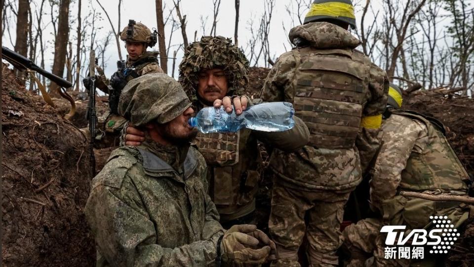 烏克蘭軍人捕獲了俄軍戰俘，雖然前線戰火無情，依舊給俘虜水喝。（圖／達志影像路透社）