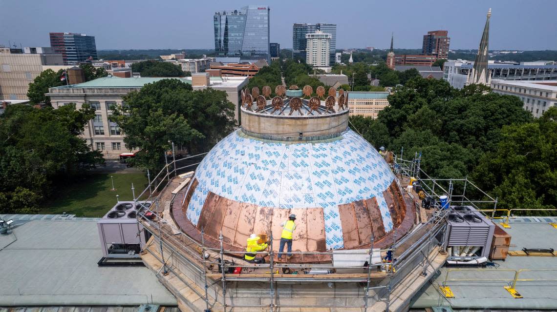 Workers install new copper panels on the dome of the North Carolina State Capitol Monday, July 17, 2023.