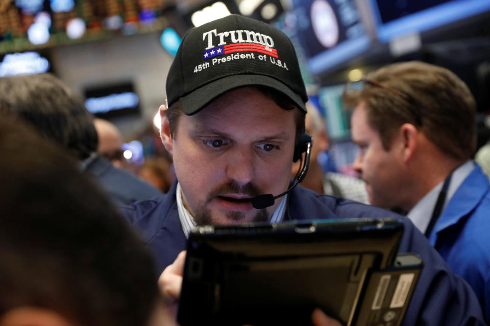 A trader wears a Donald Trump hat while working on the floor of the New York Stock Exchange (NYSE) shortly after the opening bell in New York, U.S., March 16, 2017.  REUTERS/Lucas Jackson