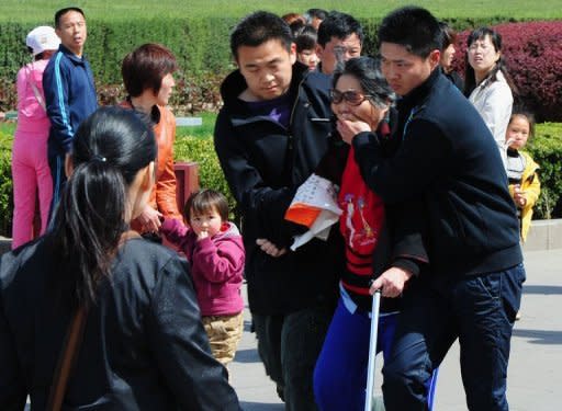 Chinese security officers arrest an elderly woman outside the Great Hall of the People which serves as the parliament building for the Communist Party of China, a day after the sacking of politician Bo Xilai from the countries powerful Politburo, in Beijing on April 11, 2012