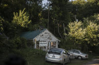 Cars are parked in front of a building with a banner which reads "Hotel" in front in Shawnee, Ohio, on Sunday, July 26, 2020. Unemployment skyrocketed to highs of nearly 18 percent amid early virus shutdowns, doubling in some counties from March to April. While those rates have come down since, nearly every county in the region is still worse off than at the start of the year. (AP Photo/Wong Maye-E)