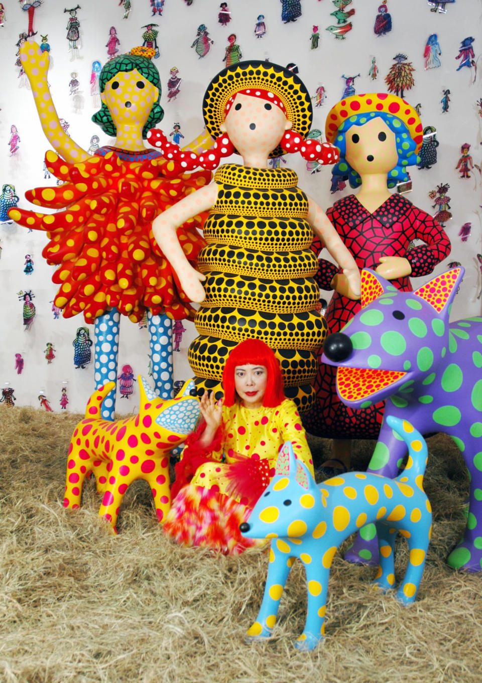 In this 2004 photo released by Yayoi Kusama Studio Inc., Japanese artist Yayoi Kusama sits amid her installation titled "Hi, Konnichiwa (hello)" at her solo exhibition "KUSAMA TRIX" at Mori Art Museum in Tokyo. Kusama's signature splash of dots has now arrived in the realm of fashion in a new collection from French luxury brand Louis Vuitton - bags, sunglasses, shoes and coats. The latest Kusama collection is showcased at its boutiques around the world, including New York, Paris, Tokyo and Singapore, sometimes with replica dolls of Kusama. (AP Photo/Yayoi Kusama Studio Inc.) NO SALES, EDITORIAL USE ONLY, CREDIT MANDATORY
