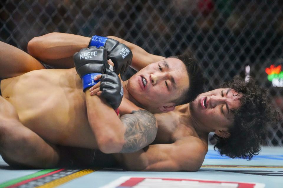 Sep 14, 2024; Las Vegas, Nevada, USA; Raul Rosas Jr. of Mexico (red gloves) fights Aoriqileng of China (blue gloves) during Riyadh Season Noche UFC 306 at The Sphere. Mandatory Credit: Stephen R. Sylvanie-Imagn Images