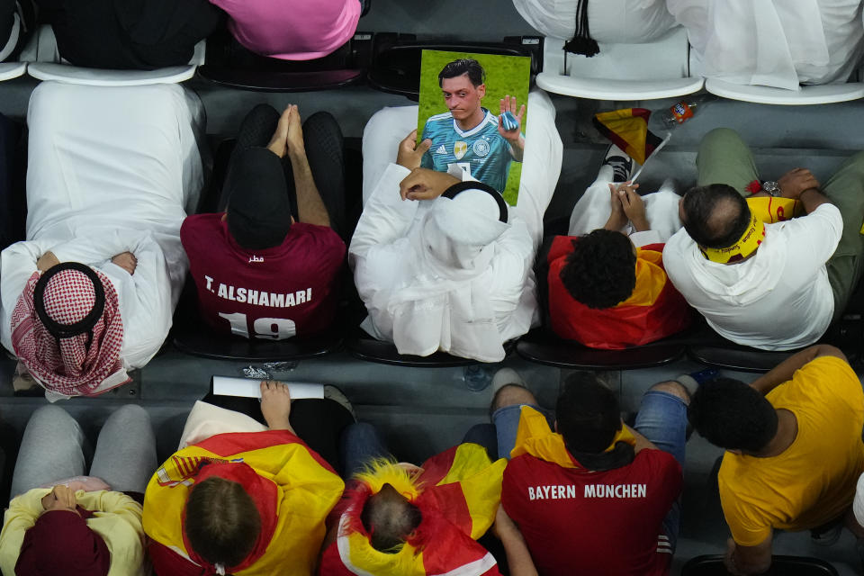 Spectators hold photos of Forman German international Mesut Ozil in the stands during the World Cup group E soccer match between Spain and Germany, at the Al Bayt Stadium in Al Khor , Qatar, Sunday, Nov. 27, 2022. (AP Photo/Petr David Josek)