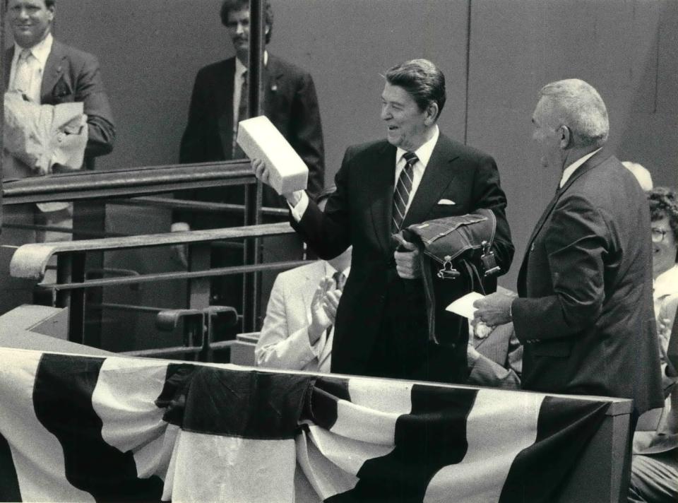 This photo of President Ronald Reagan's visit to Oshkosh is dated May 30, 1985. Reagan holds a block of cheddar cheese and Oshkosh B'Gosh bib overalls presented to him.