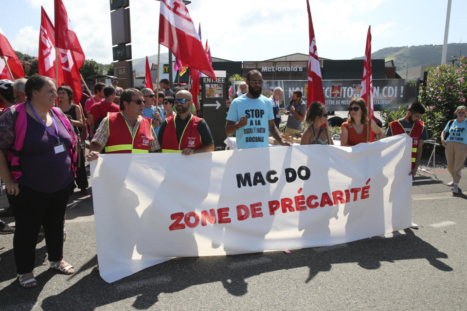 Unionists demonstrate with a banner reading "Mac Do, social insecurity zone" in front of a McDonald's restaurant, Thursday, Aug. 22, 2019 in Hendaye, southwestern France. The G-7 summit has for the first time co-opted the message of its protesters: Capitalism has led to damaging inequality, hurting the environment also harms the global economy, and a handful of rich countries can't be the only ones making decisions for the world. (AP Photo/Bob Edme)