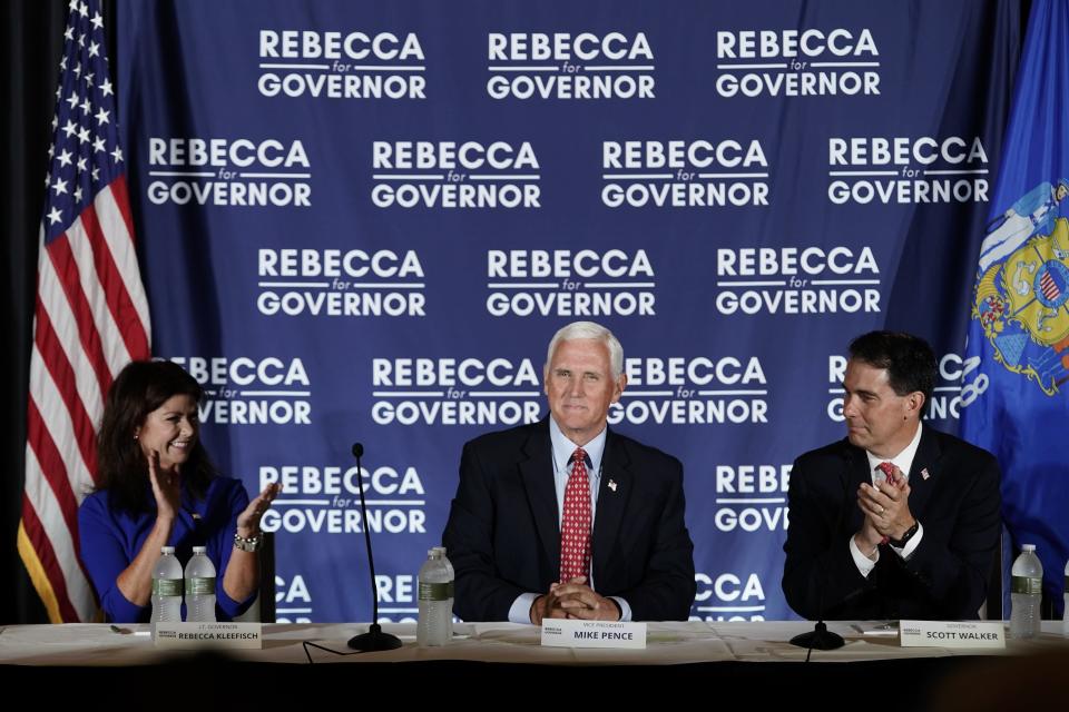 Former Vice President Mike Pence is flanked by Wisconsin Rebublican gubernatorial candidate Rebecca Kleefisch and former Gov. Scott Walker as they participate in a round table discussion Wednesday, Aug. 3, 2022, in Pewaukee, Wis. (AP Photo/Morry Gash)