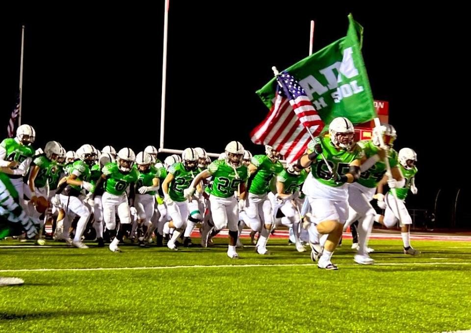 Badin High School's football team runs onto the field Friday, Nov. 17, 2023, to play the Division III regional final against Celina.