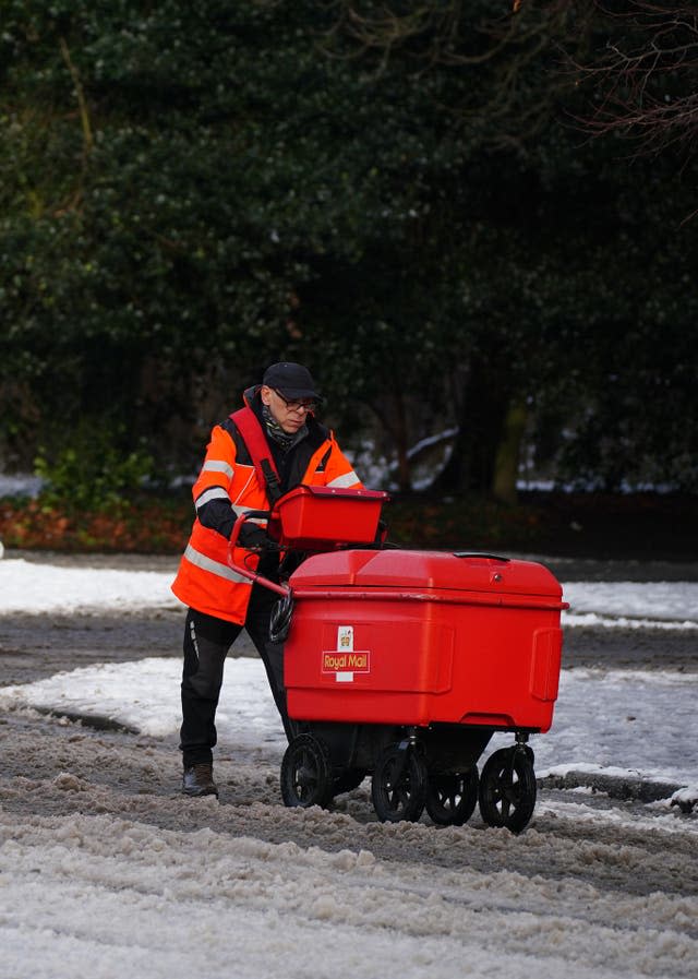 A postman battles through the snow in Sefton Park, Liverpool.