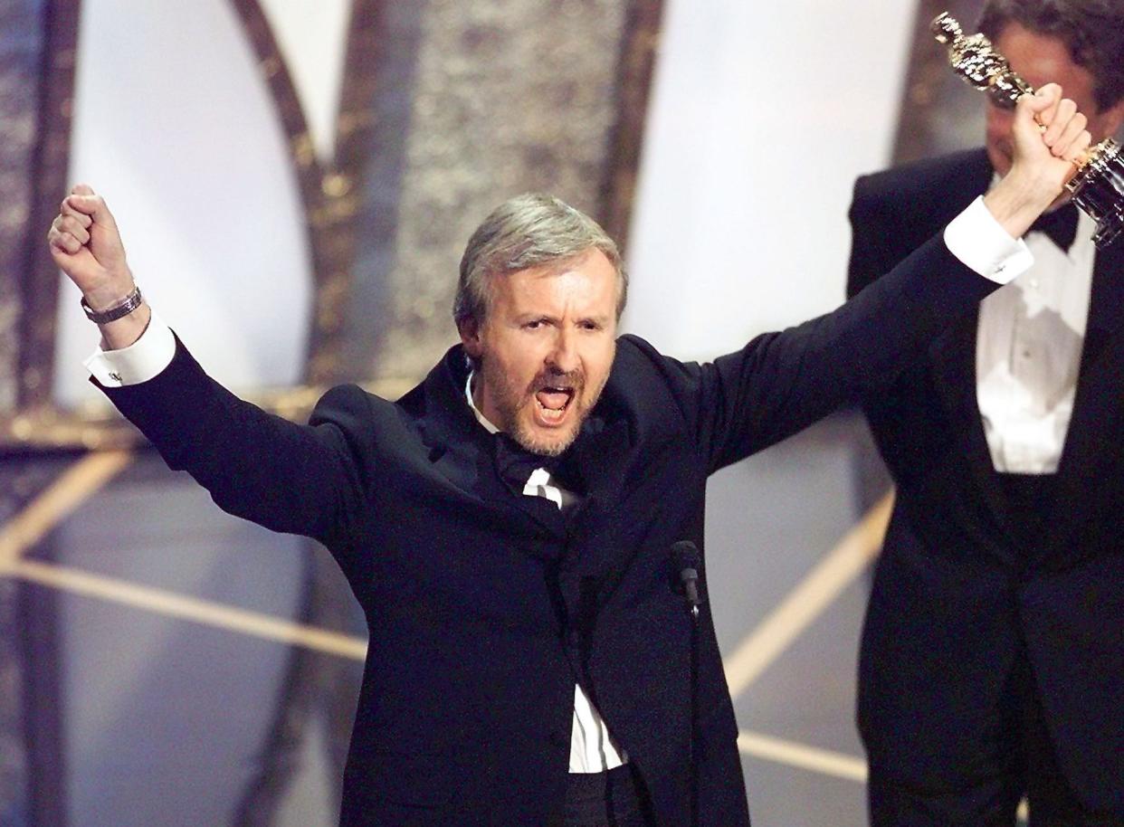 James Cameron raises his Oscar after winning Best Director for <em>Titanic</em> at the 70th Academy Awards in 1998. (Photo: Timothy A. Clary/AFP/Getty Images)