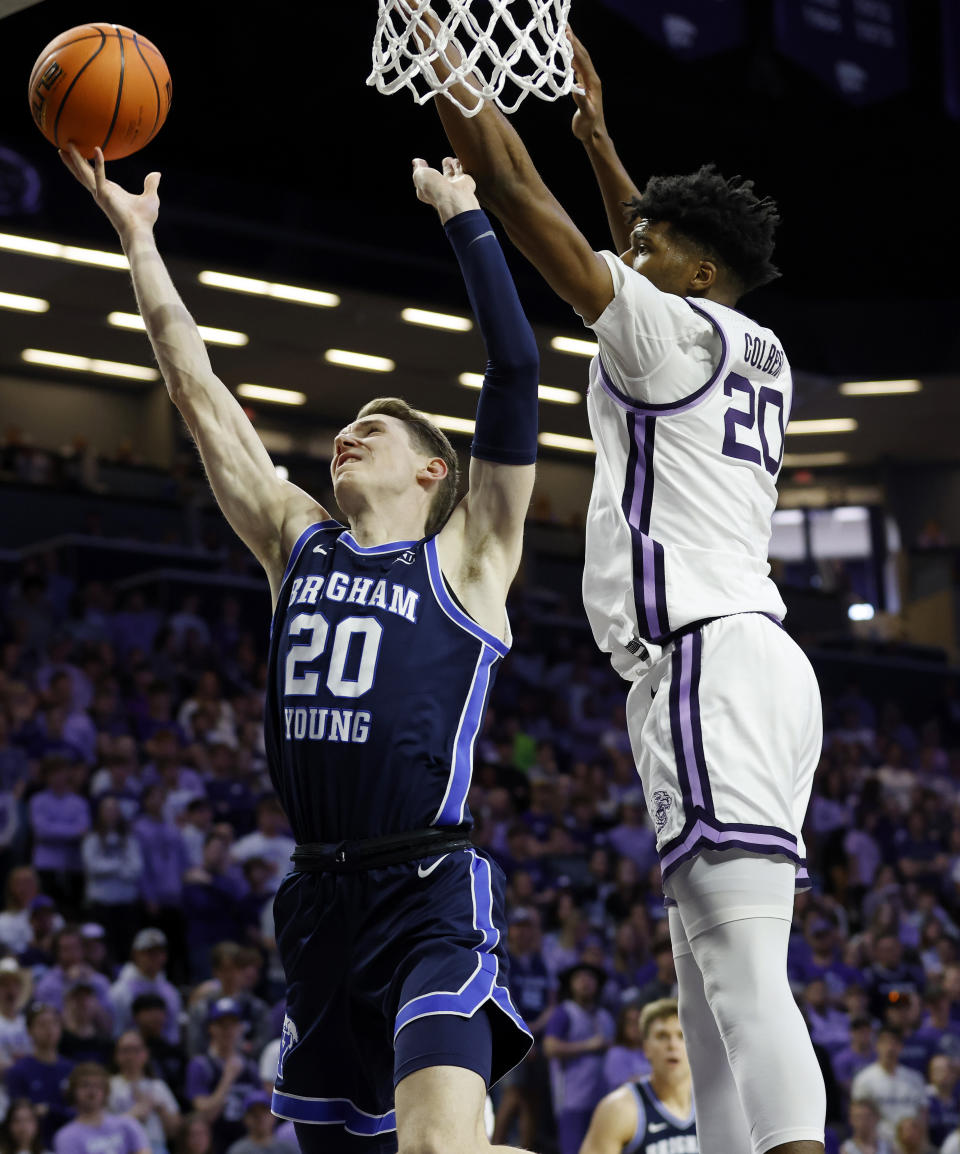 BYU guard Spencer Johnson (20) scores against Kansas State forward Jerrell Colbert (20) during the first half of an NCAA college basketball game, Saturday, Feb. 24, 2024, in Manhattan, Kan. (AP Photo/Colin E. Braley)