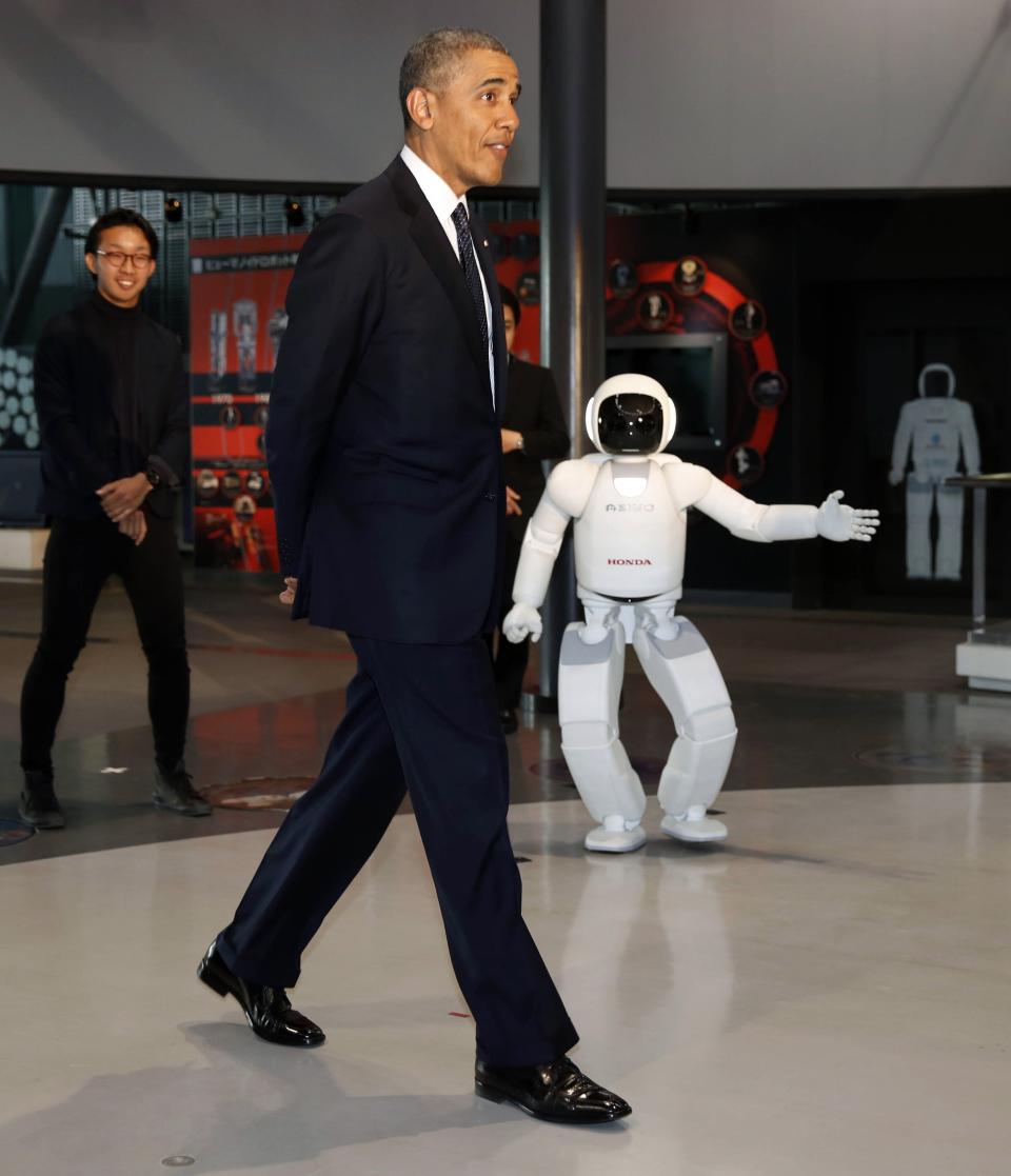 U.S. President Barack Obama walks next to "Asimo" the robot while visiting Miraikan in Tokyo