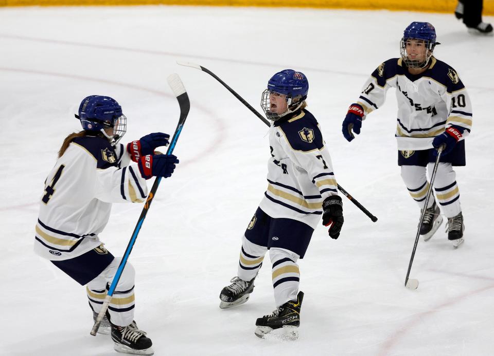 Webster’s Jessica Nappi celebrates with teammates Ella Buss and Harper Blakley. Webster made history by playing in the first girl’s high school hockey game in Section V. Webster lost to Ithaca 7-2.