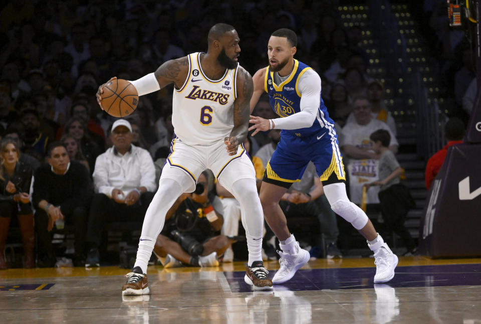 A estrela do Los Angeles Lakers, LeBron James, controla a bola contra a estrela do Golden State Warriors, Stephen Curry, durante o jogo 3 da série semifinal da Conferência Oeste na Crypto.com Arena em 6 de maio de 2023 em Los Angeles.  (via Getty Images)