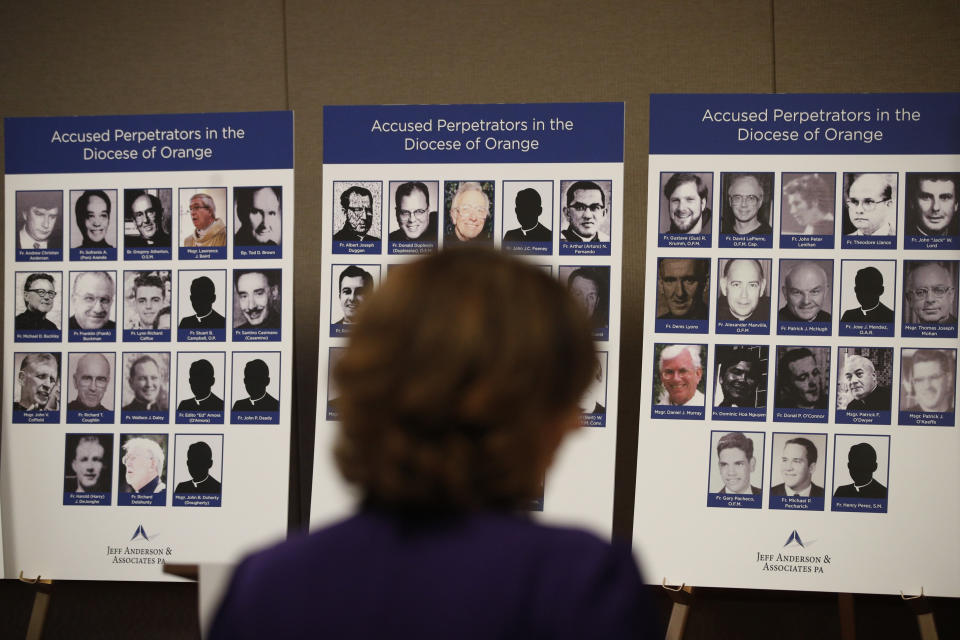 An advocate and survivor of sexual abuse, looks at the photos of Catholic priests accused of sexual misconduct by victims during a news conference Thursday, Dec. 6, 2018, in Orange, Calif. Advocates for survivors of child sex abuse say they have compiled a list of 72 priests who served in the Southern California Diocese of Orange and who are accused of abusing kids. Lawyer Mike Reck on Thursday said that's many more than those reported by the Diocese and demanded greater transparency. The Diocese of Orange says the lawyers are trying to re-litigate old claims that the church takes any accusations of abuse "extraordinarily seriously." (AP Photo/Jae C. Hong)