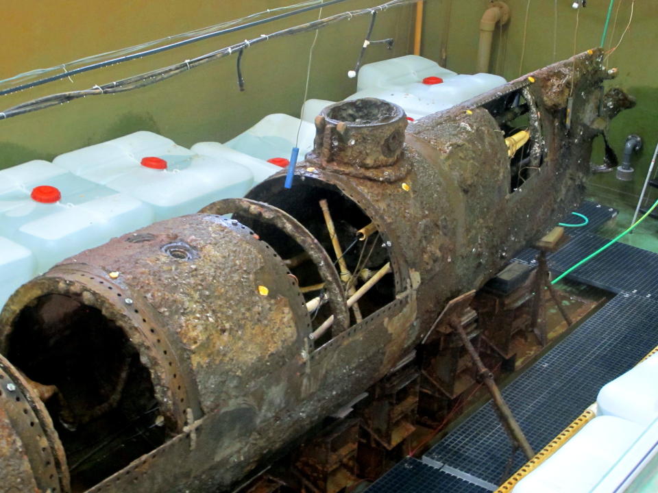 The Confederate submarine H.L. Hunley sits in a conservation tank at a lab in North Charleston, S.C., before it was to be covered in a chemical bath on Thursday, May 1, 2014. Bathing the hand-cranked Hunley in chemicals marks a new step in the conservation of the first sub in history to sink an enemy warship. The chemical bath will help remove salts and the encrustation on the submarine's hull. The Hunley sank a Union blockade ship off the South Carolina coast in 1864. It was discovered in 1995 and raised in 2000 and brought to the North Charleston lab. (AP Photo/Bruce Smith)