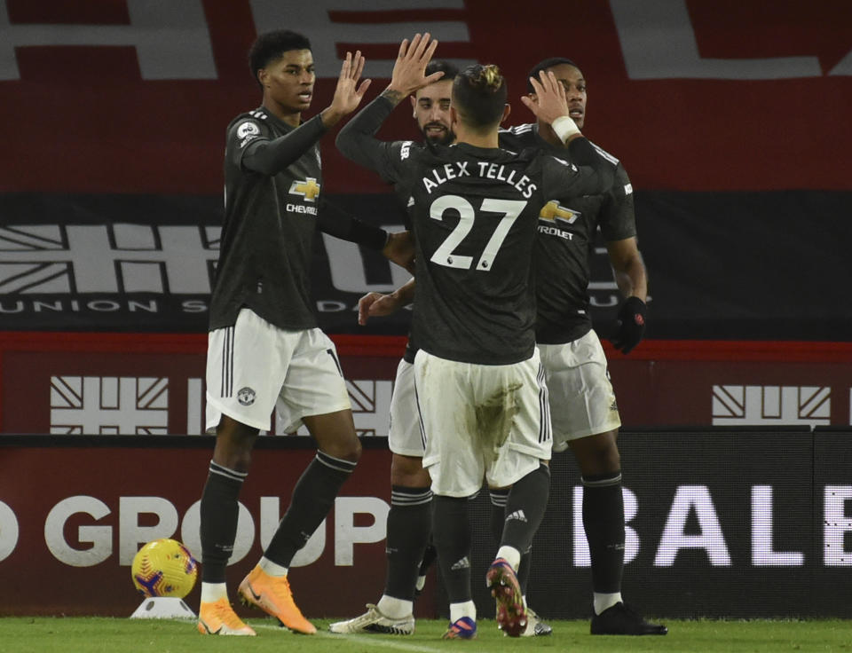 Marcus Rashford (izquierda), del Manchester United, festeja con sus compañeros luego de anotar en un partido de la Liga Premier inglesa ante Sheffield United, el jueves 17 de diciembre de 2020 (AP Foto/Rui Vieira, Pool)