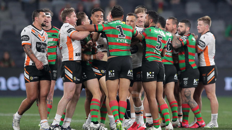 Players, pictured here coming together in fiery scenes between the Rabbitohs and Tigers.