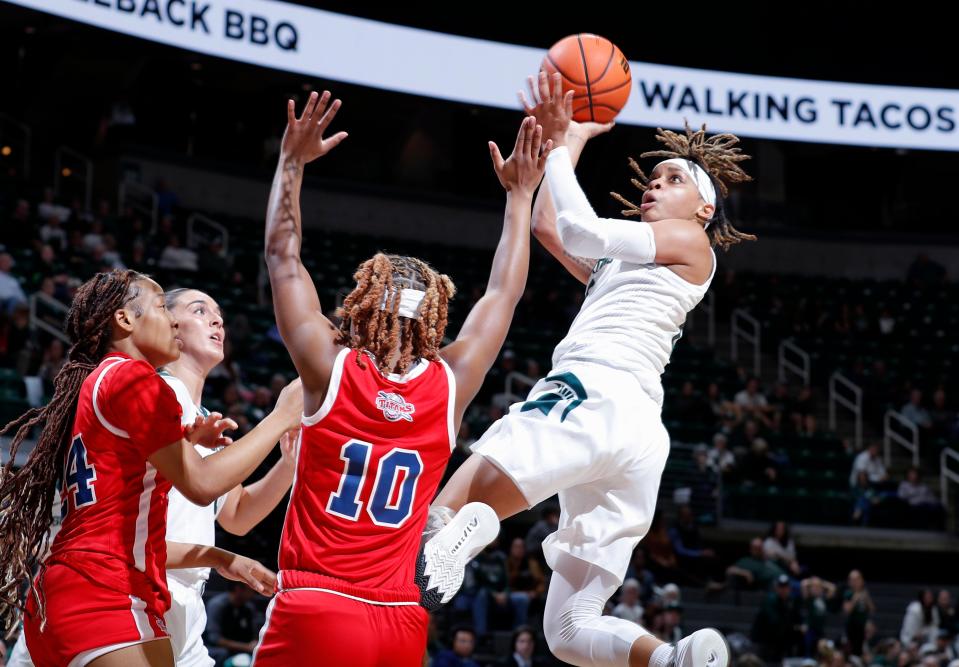 Michigan State's DeeDee Hagemann, right, puts up a twisting shot against Detroit Mercy's Paris Gilmore (10) and Kamari Forrest, left, Thursday, Nov. 16, 2023, in East Lansing, Mich.