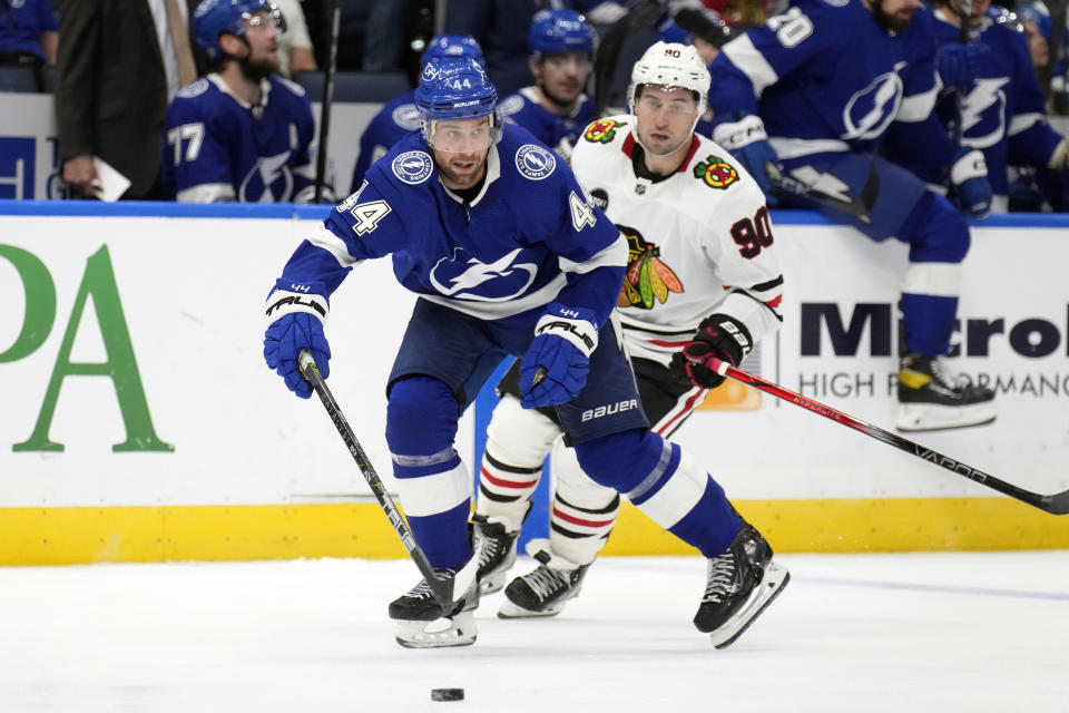 Tampa Bay Lightning defenseman Calvin de Haan (44) passes the puck in front of Chicago Blackhawks center Tyler Johnson (90) during the third period of an NHL hockey game Thursday, Nov. 9, 2023, in Tampa, Fla. (AP Photo/Chris O'Meara)