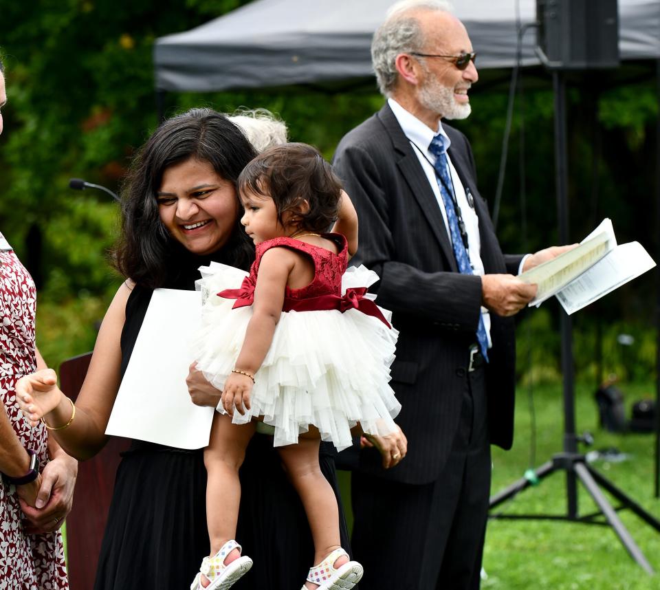 Priti Patel of Fitchburg is all smiles with her 14-month-old daughter, Prisha, after receiving her certificate of naturalization