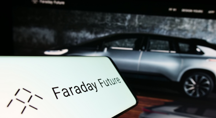 Mobile phone with logo of electric vehicle company Faraday Future Inc. on screen in front of website. Focus on center-right of phone display. Unmodified photo. FFIE stock
