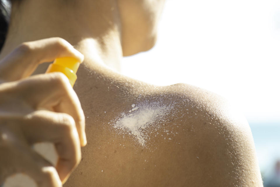 Person getting sunscreen sprayed on them