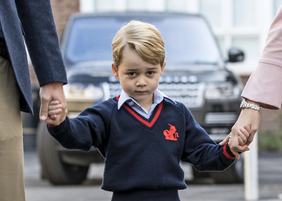 TOPSHOT - Britain's Prince George (C) accompanied by Britain's Prince William (L), Duke of Cambridge arrives for his first day of school at Thomas's school where he is met by Helen Haslem (R) head of the lower school in southwest London on September 7, 2017. / AFP PHOTO / POOL / RICHARD POHLE        (Photo credit should read RICHARD POHLE/AFP/Getty Images)