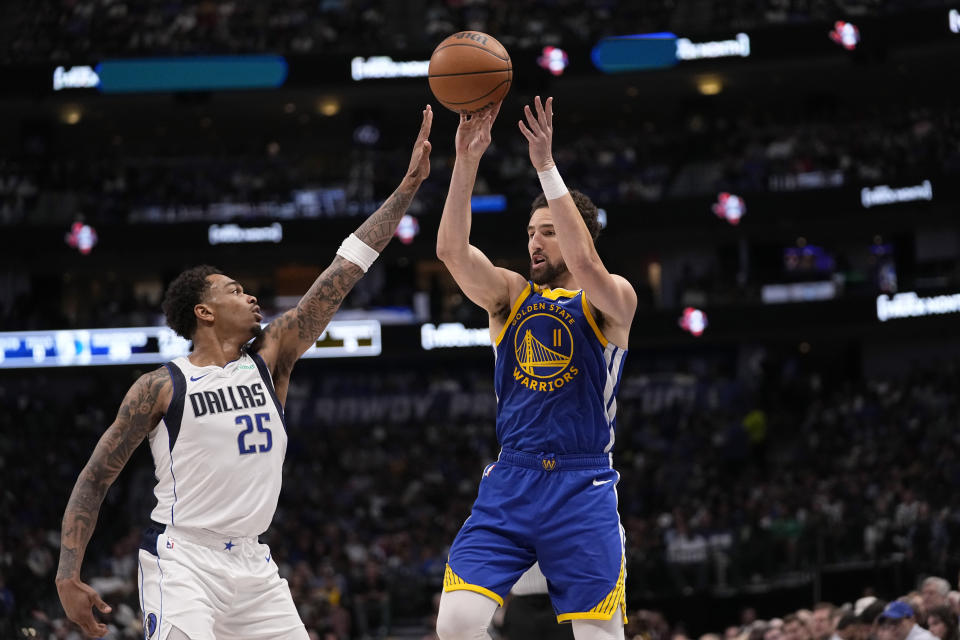 Golden State Warriors guard Klay Thompson (11) passes the ball as Dallas Mavericks forward P.J. Washington (25) defends during the first half of an NBA basketball game in Dallas, Wednesday, March 13, 2024. (AP Photo/Tony Gutierrez)
