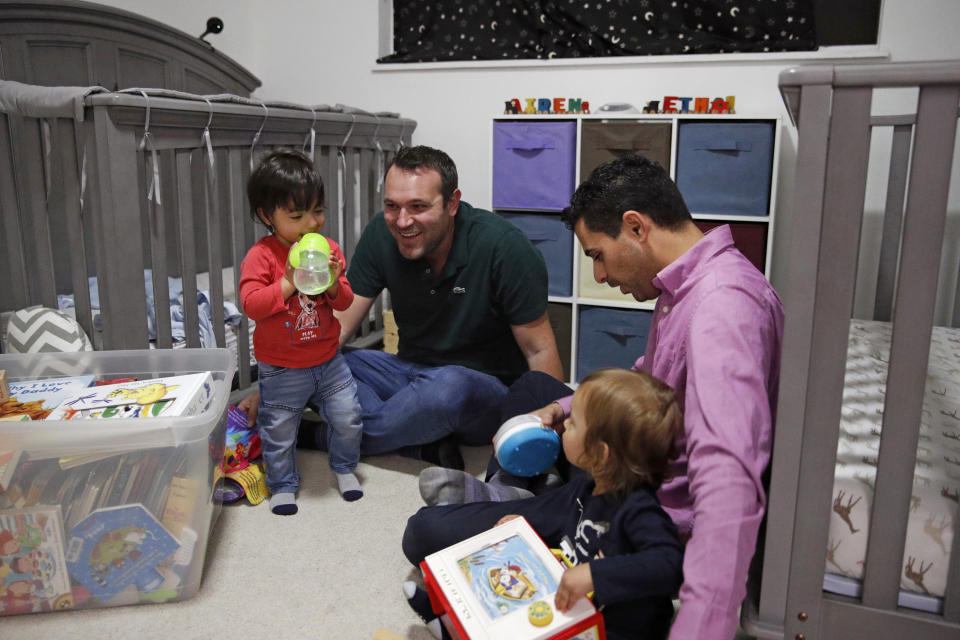 FILE - In this Jan. 23, 2020, file photo, Elad Dvash-Banks, right, and his partner Andrew, play with their twin sons, Ethan, left, and Aiden in their apartment in Los Angeles. A federal appeals court has ruled against the U.S. State Department in its quest to deny the citizenship of the son born abroad to the gay married couple. In a decision issued Oct. 9, 2020, the 9th U.S. Circuit Court of Appeals unanimously upheld a lower court ruling recognizing the citizenship from birth of Ethan Dvash-Banks, a twin boy born abroad by surrogacy to Andrew and Elad Dvash-Banks, a married gay couple. (AP Photo/Jae C. Hong, File)