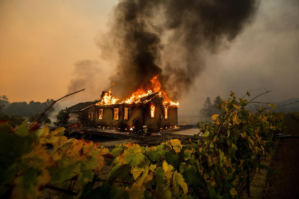 Vines surround a burning building as the Kincade Fire burns through the Jimtown community of unincorporated Sonoma County, Calif., Oct. 24, 2019. (AP Photo/Noah Berger)