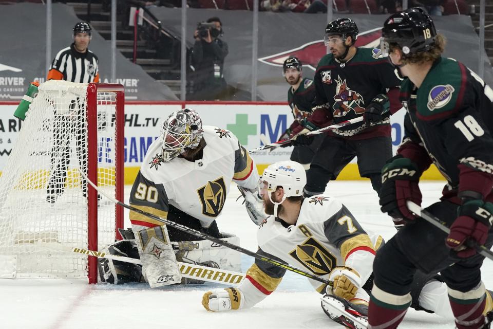Arizona Coyotes center Christian Dvorak (18) scores a goal against Vegas Golden Knights goaltender Robin Lehner (90) as Golden Knights defenseman Alex Pietrangelo (7), Coyotes center Nick Schmaltz, second from right, and Coyotes right wing Conor Garland look on during the first period of an NHL hockey game Friday, Jan. 22, 2021, in Glendale, Ariz. (AP Photo/Ross D. Franklin)