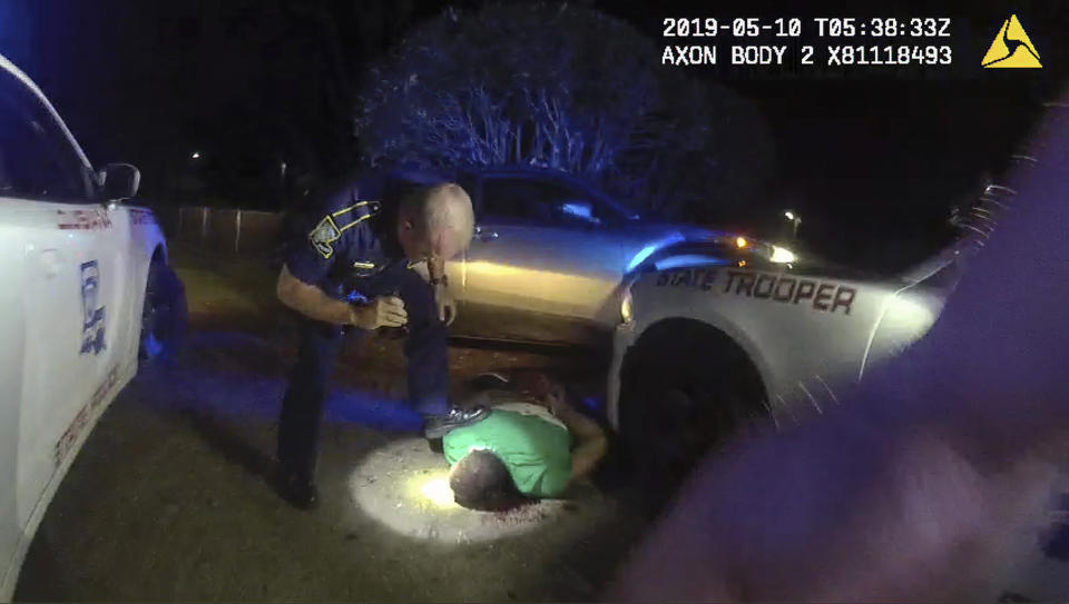 This image from video from Louisiana state police state trooper Dakota DeMoss' body-worn camera, shows trooper Kory York bending over with his foot on Ronald Greene's shoulder after he was taken into custody on May 10, 2019, outside of Monroe, La. (Louisiana State Police via AP)