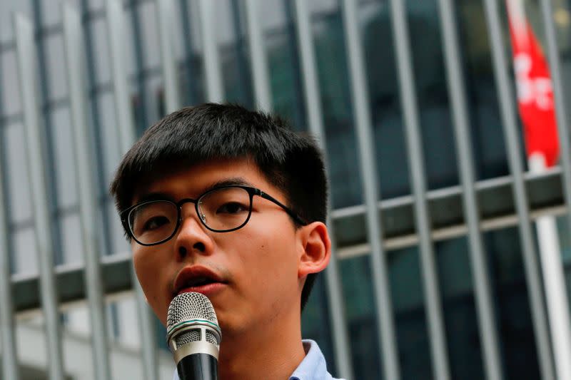 FILE PHOTO - Pro-democracy activist Joshua Wong speaks to journalists after being disqualified from running in the local district's council elections in November, in Hong Kong