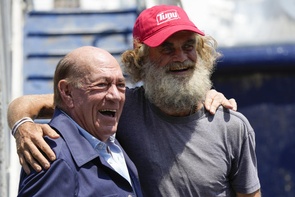Australian Timothy Lyndsay Shaddock, right, poses for photos with Grupo Mar President Antonio Suarez during a welcoming ceremony after being rescued from sea and arriving to port in Manzanillo, Mexico, Tuesday, July 18, 2023. After being adrift with his dog for three months, Shaddock and his dog were rescued by the crew of the tuna boat owned by Grupo Mar from an incapacitated catamaran in the Pacific Ocean some 1,200 miles from land. (AP Photo/Fernando Llano)