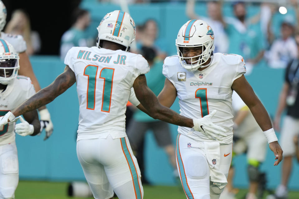 Miami Dolphins quarterback Tua Tagovailoa (1) celebrates a touchdown with wide receiver Cedrick Wilson Jr. (11) during the second half of an NFL football game, Sunday, Nov. 13, 2022, in Miami Gardens, Fla. (AP Photo/Wilfredo Lee)