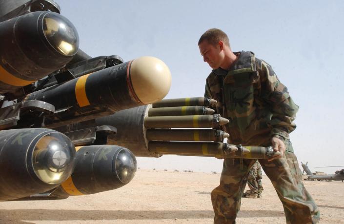 US Army armament crew specialist loads the rocket pod of an an Apache AH-64D attack helicopter also armed with Hellfire missiles in the central Iraqi desert on March 31, 2003 (AFP Photo/Romeo Gacad)