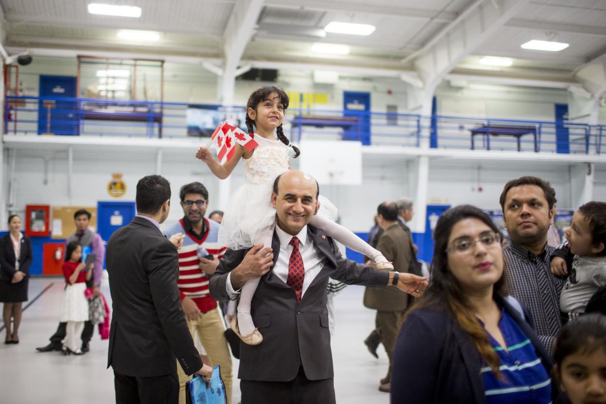 TORONTO, ON - MAY 2: Hadi Elhami, originally from Iran, carries his daughter, Arnika Elhami, on his shoulder during a citizenship ceremony held at the Royal Canadian Navy local reserve division HMCS York. 250 new Canadians took the oath on this day        (Carlos Osorio/Toronto Star via Getty Images)