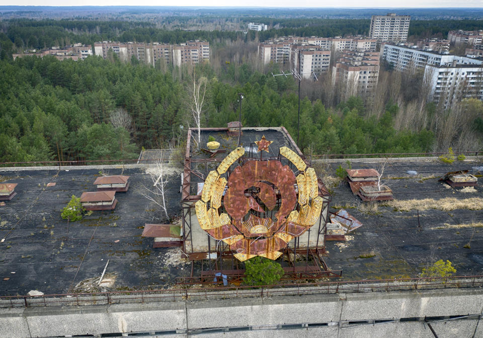 The rusty emblem of the Soviet Union is seen over the ghost town of Pripyat close to the Chernobyl nuclear plant, Ukraine, Thursday, April 15, 2021. The vast and empty Chernobyl Exclusion Zone around the site of the world’s worst nuclear accident is a baleful monument to human mistakes. Yet 35 years after a power plant reactor exploded, Ukrainians also look to it for inspiration, solace and income. (AP Photo/Efrem Lukatsky)