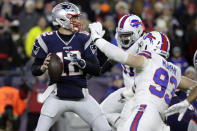 FILE - In this Dec. 21, 2019, file photo, New England Patriots quarterback Tom Brady, left, passes under pressure from Buffalo Bills defensive end Trent Murphy (93) during the first half of an NFL football game in Foxborough, Mass. Between them, Brady and Drew Brees have played 38 pro football seasons, 39 if you count 2008 when the New England star wrecked his knee in Week 1, and could be doing so against each other on Feb. 2 in a little thing called the Super Bowl. (AP Photo/Elise Amendola, File)