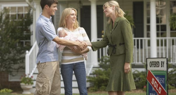 Young Family with Real Estate Agent in Front of New House