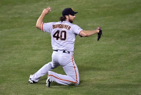 Oct 21, 2014; Kansas City, MO, USA; San Francisco Giants starting pitcher Madison Bumgarner throws to first base after catching a ball hit by Kansas City Royals first baseman Eric Hosmer (not pictured) in the 6th inning during game one of the 2014 World Series at Kauffman Stadium. Peter G. Aiken-USA TODAY Sports